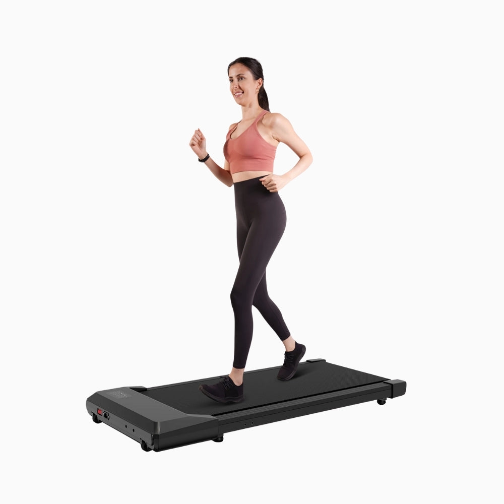 Woman using a portable walking pad treadmill on a white background