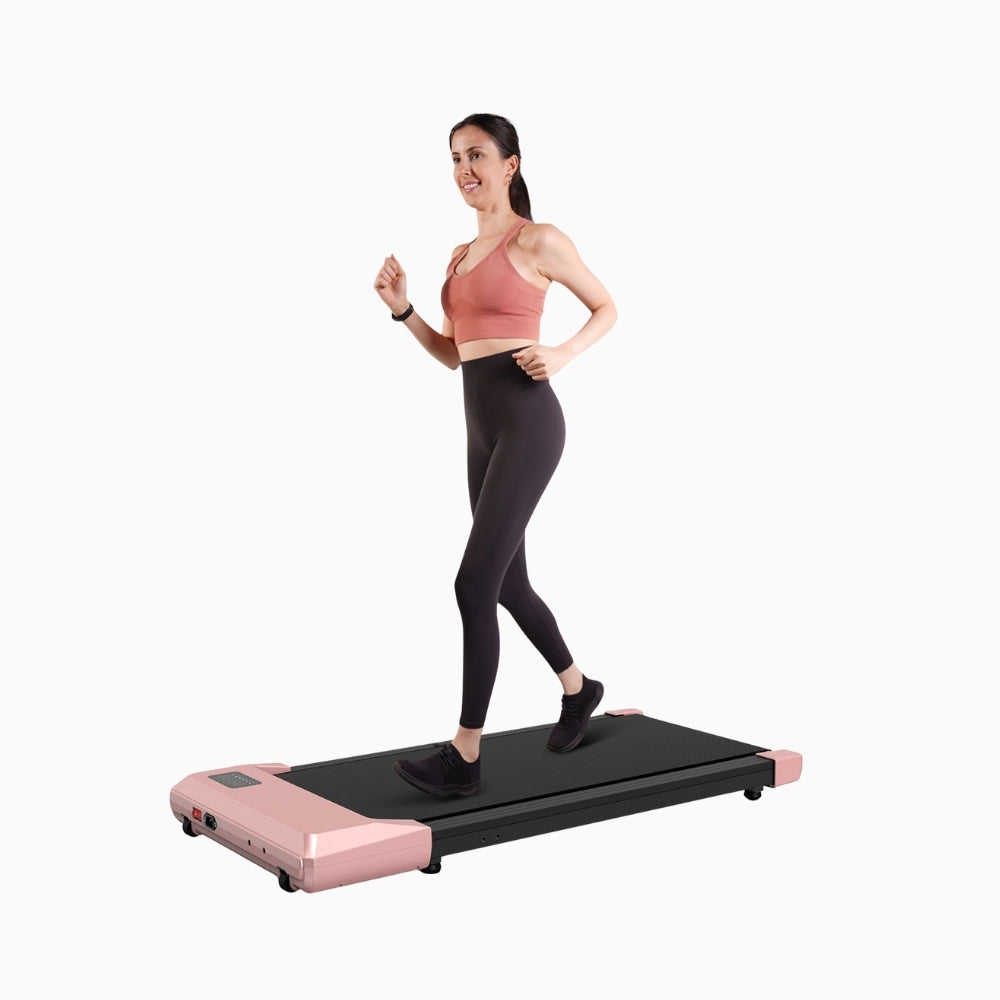 Woman using a pink and black walking pad treadmill on a white background